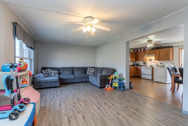 Living area with light wood-style flooring, a ceiling fan, and separate washer and dryer | Image 22