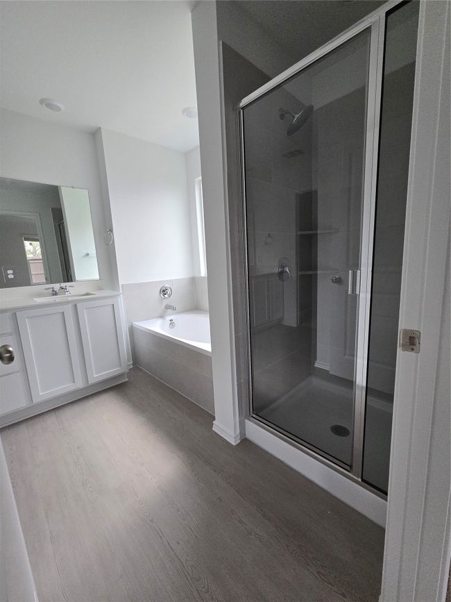 Bathroom featuring wood finished floors, vanity, a garden tub, and a shower stall | Image 16