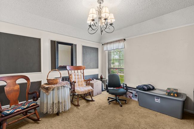 Living area featuring lofted ceiling, a textured ceiling, carpet flooring, and a notable chandelier | Image 10