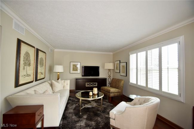 Living room with wood finished floors, crown molding, and baseboards | Image 6
