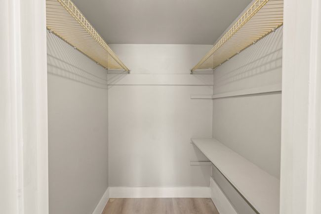 Spacious closet with light wood-type flooring | Image 27