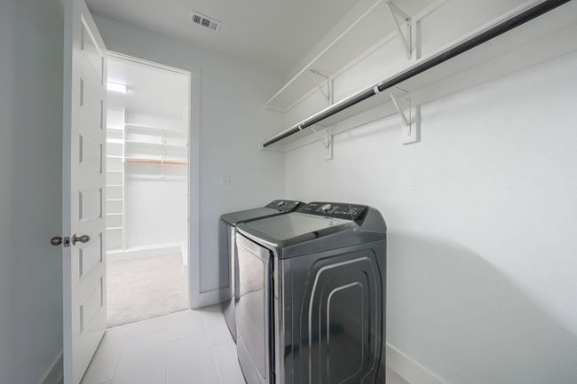 Laundry room featuring independent washer and dryer, baseboards, and light carpet | Image 23