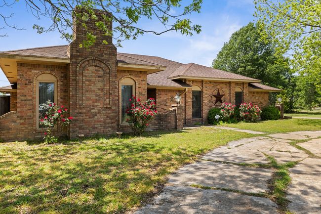 View of front of house with a chimney, a front lawn, brick siding, and roof with shingles | Image 4