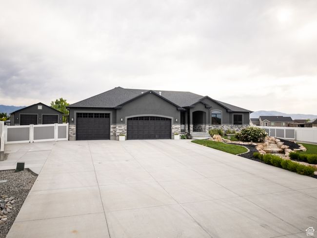 French country home with an attached garage, driveway, stucco siding, and stone siding | Image 8