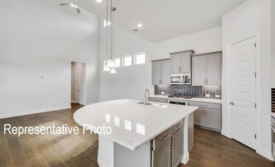 Kitchen featuring appliances with stainless steel finishes, sink, pendant lighting, and a kitchen island with sink | Image 2