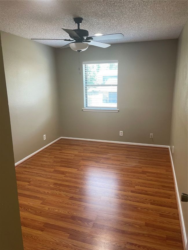 Empty room featuring ceiling fan, wood-type flooring, and a textured ceiling | Image 21