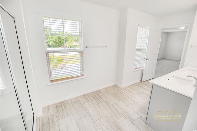 Full bath featuring double vanity, baseboards, and an enclosed shower | Image 23