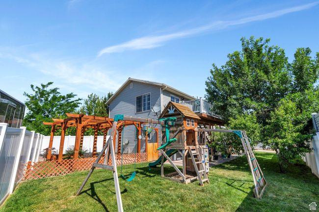 View of jungle gym featuring a pergola and a fenced backyard | Image 20