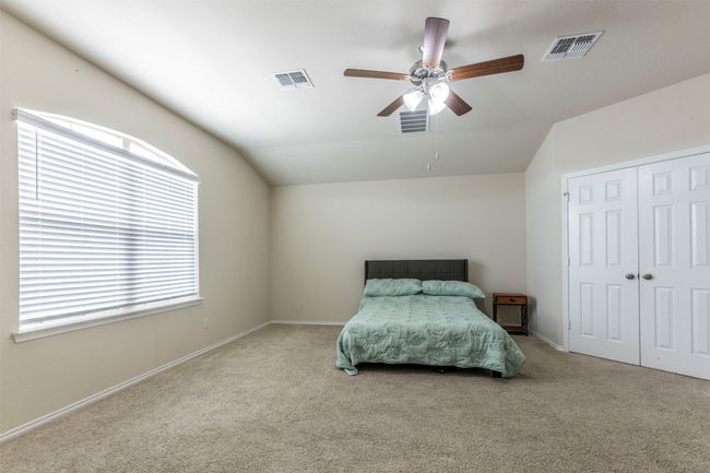 Carpeted bedroom with multiple windows, vaulted ceiling, and visible vents | Image 13