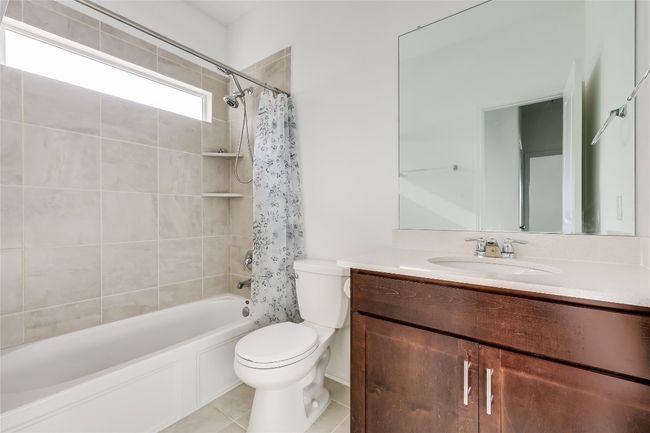 Full bath featuring vanity, shower / bathtub combination with curtain, and tile patterned floors | Image 26