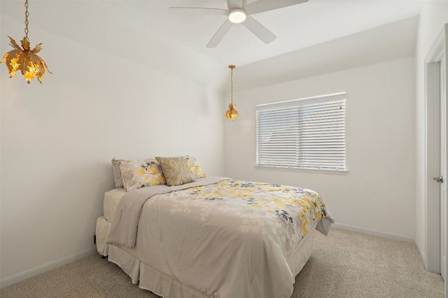Bedroom with light carpet, baseboards, lofted ceiling, and ceiling fan | Image 20
