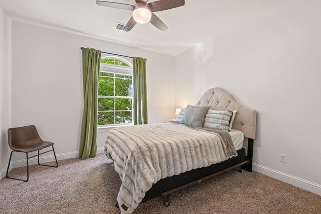 Bedroom featuring carpet floors, baseboards, ceiling fan, and visible vents | Image 32