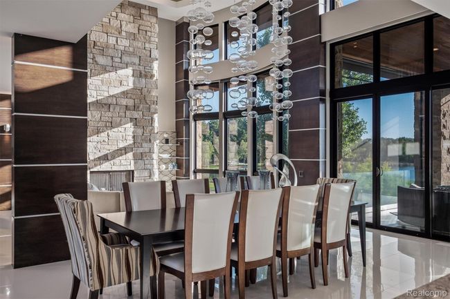 Dining area featuring light tile patterned floors and a high ceiling | Image 10