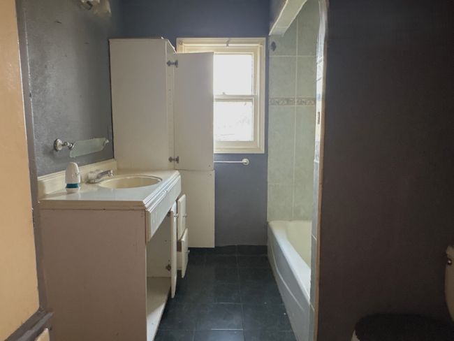 Bathroom with tile patterned flooring, a washtub, toilet, vanity, and a shower | Image 9