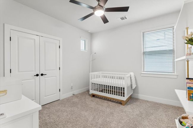 Bedroom with carpet flooring, a nursery area, a closet, and ceiling fan | Image 19
