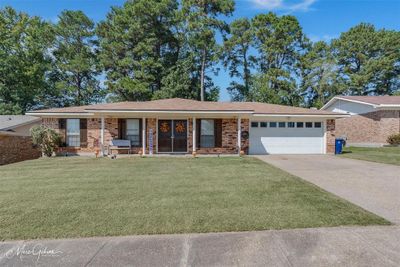 Single story home with a front lawn, a porch, and a garage | Image 1