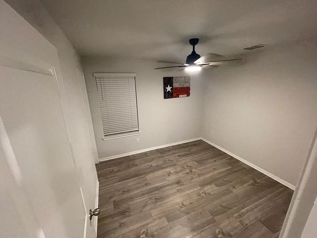 Spare room featuring baseboards, visible vents, ceiling fan, and dark wood-style flooring | Image 9