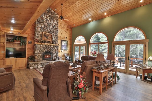 Living room with high vaulted ceiling, plenty of natural light, hardwood / wood-style flooring, french doors, and wooden ceiling | Image 6