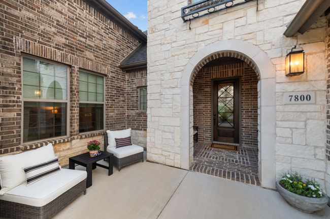 View of exterior entry featuring an arched stone entry | Image 5