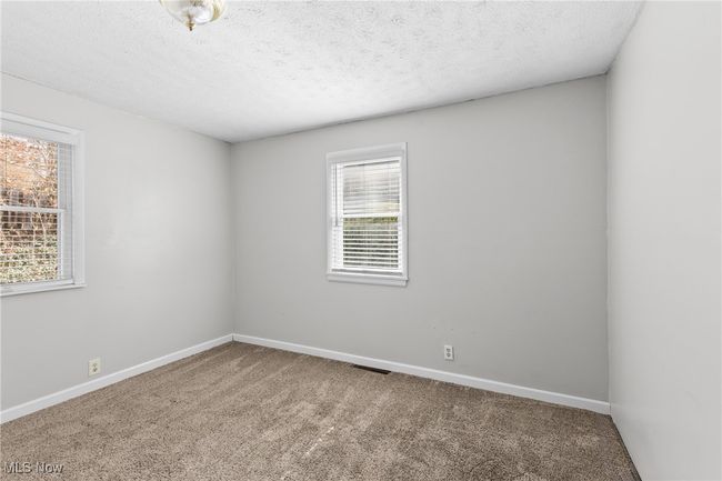 Carpeted spare room featuring visible vents, baseboards, and a textured ceiling | Image 16