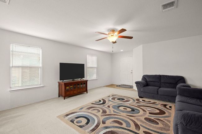 Living room with carpet floors and ceiling fan | Image 4