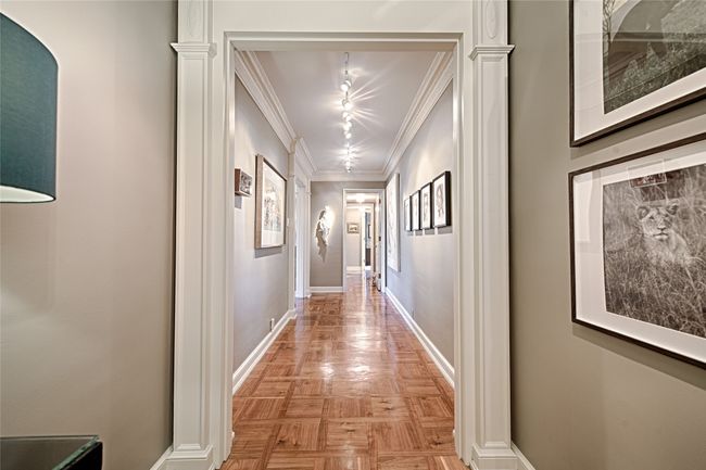 Corridor gallery with ornamental molding and baseboards looking towards the second bedroom | Image 21