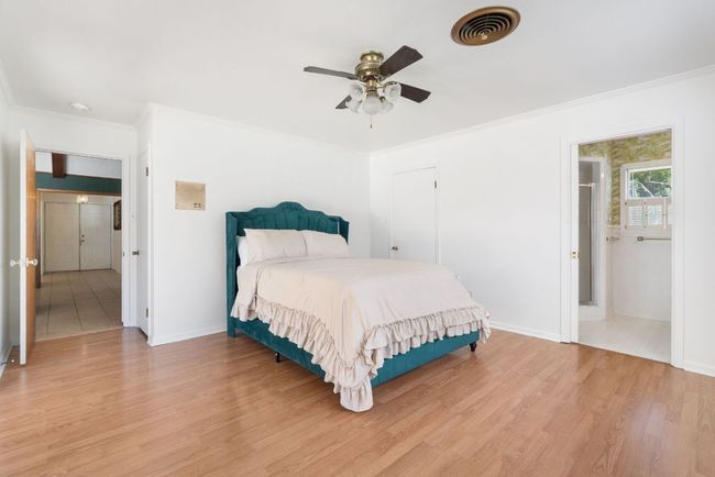Primary Bedroom featuring crown molding, light wood-style flooring, and a ceiling fan | Image 19