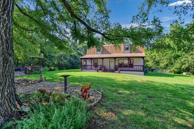 Rear view of house with a lawn, a shingled roof, and a porch | Image 32