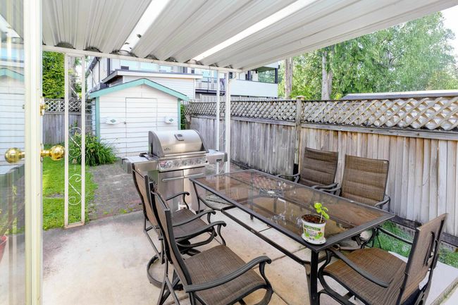 Fenced backyard with outdoor dining area, a patio area, and area for grilling | Image 12