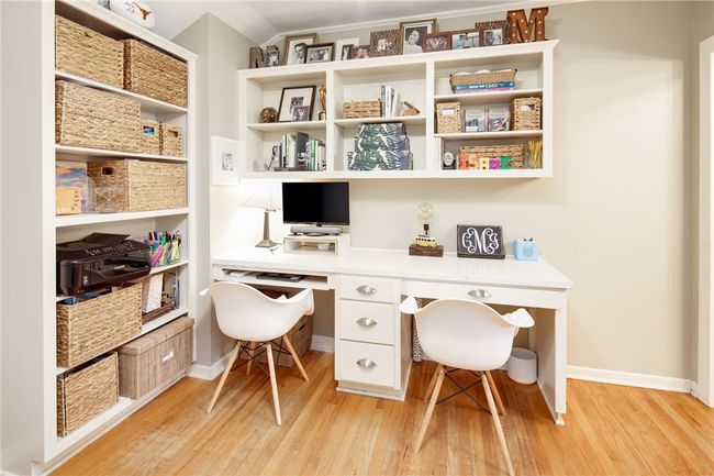 Office space with light wood finished floors, built in desk, and baseboards | Image 27