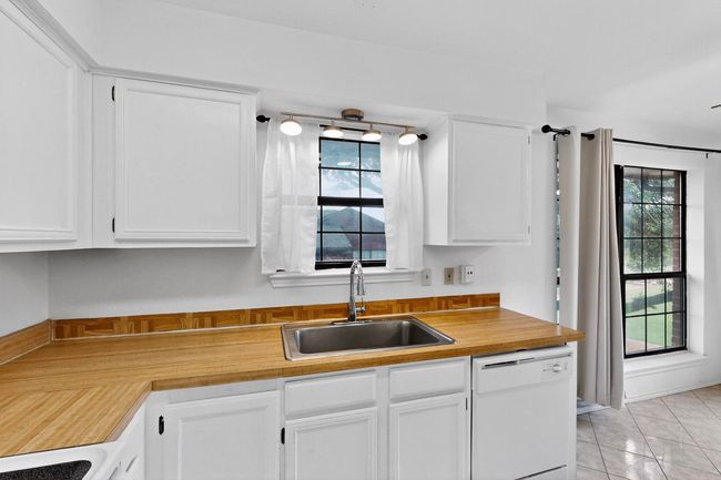Kitchen featuring white dishwasher, a sink, and white cabinets | Image 17