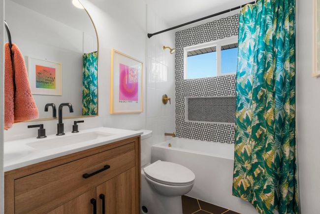 Shared Bathroom featuring shower / tub combo, quartz vanity, designer mirror, tiles, and fixtures | Image 25
