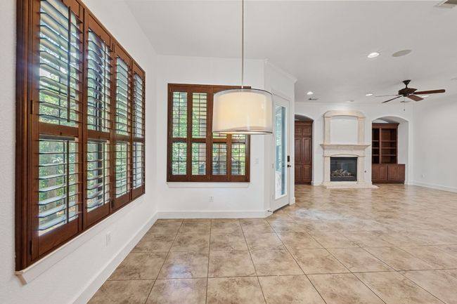 Unfurnished dining area with healthy amount of natural light, tile patterned flooring, a ceiling fan, and recessed lighting | Image 13
