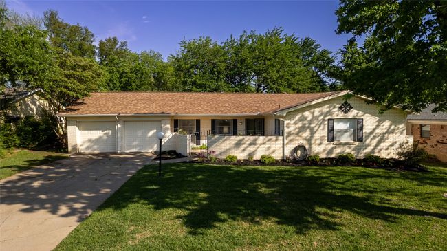 Ranch-style house featuring a front lawn, driveway, a garage, and brick siding | Image 23