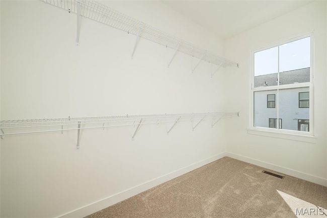 Spacious closet with light carpet | Image 26