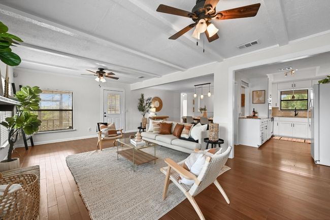 Living area featuring ceiling fan, hardwood / wood-style floors, beamed ceiling, and baseboards | Image 5