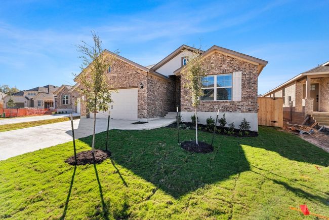 Ranch-style house featuring an attached garage, driveway, a front yard, and brick siding | Image 29