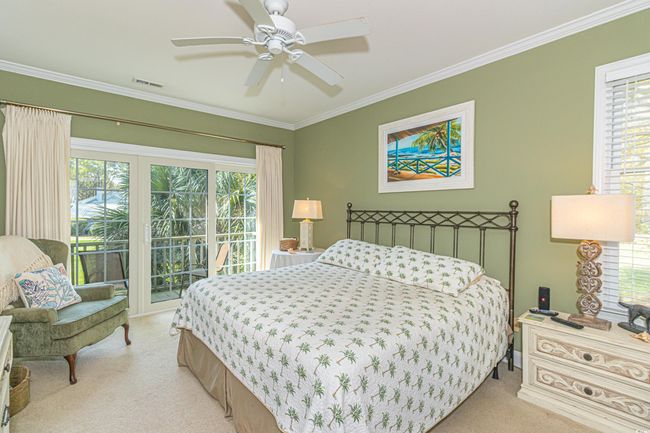 Bedroom featuring crown molding, light colored carpet, access to exterior, visible vents, and a ceiling fan | Image 15