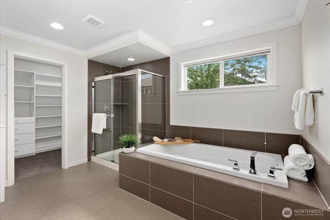 Sleek tile compliments this bathroom with walk in closet | Image 25