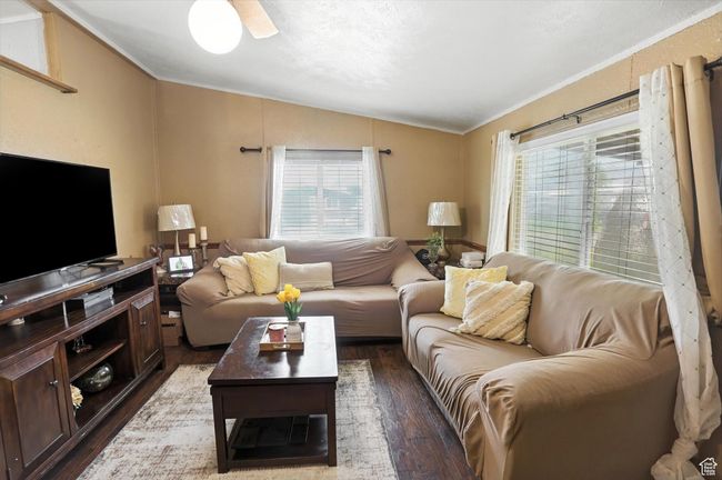 Living room with vaulted ceiling, dark wood finished floors, ornamental molding, and plenty of natural light | Image 4