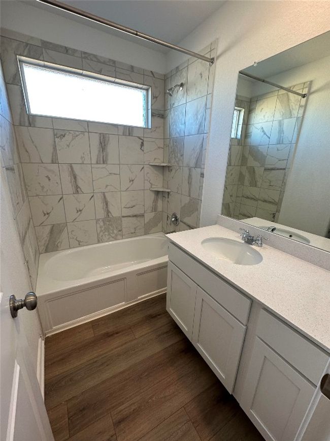 Bathroom with shower / tub combination, wood finished floors, and vanity | Image 18