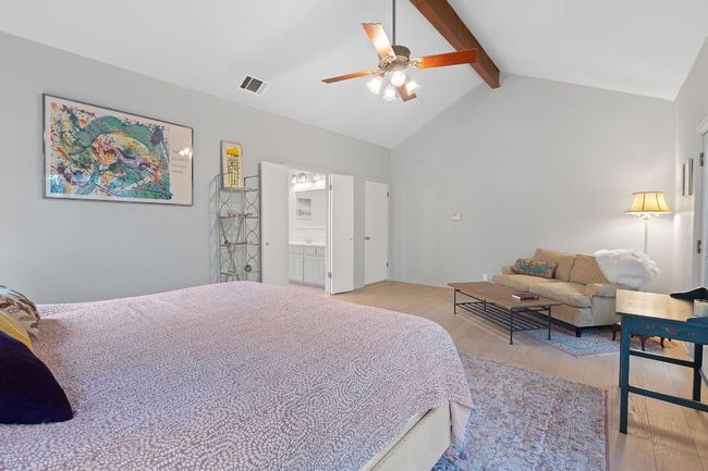 Bedroom with light wood-style flooring, beamed ceiling, ensuite bath, ceiling fan, and high vaulted ceiling | Image 19