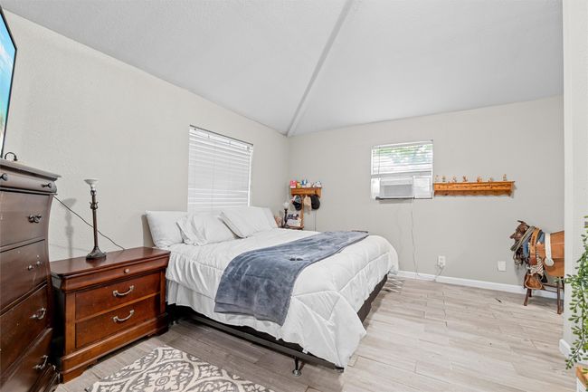 Bedroom with light wood-style floors, baseboards, and lofted ceiling | Image 30