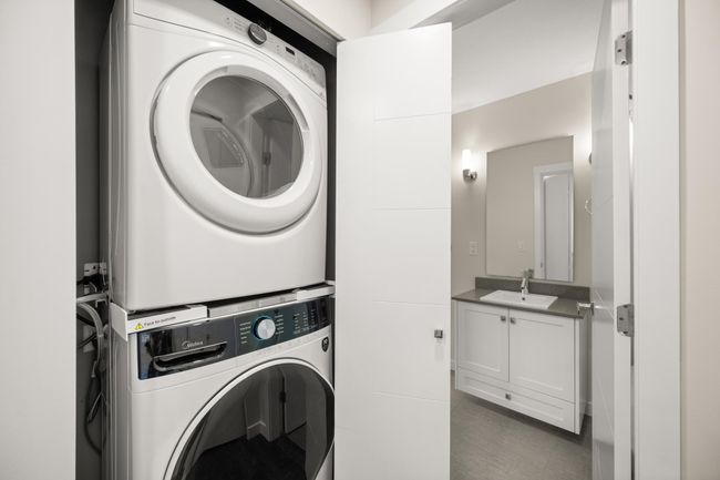 Laundry room with stacked washer / drying machine and tile patterned floors | Image 19
