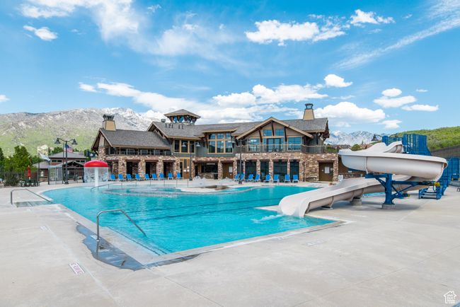 Community pool with a water slide, a mountain view, and a patio area | Image 52