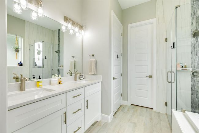 The primary bathroom features dual sinks, walk-in shower, and separate tub. | Image 23