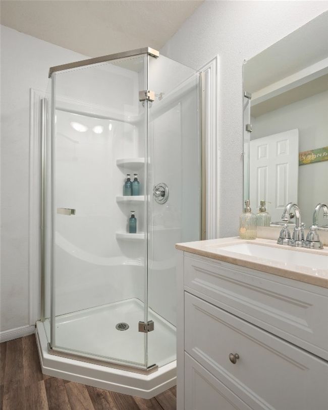 Full bath with a stall shower, vanity, and wood finished floors | Image 11