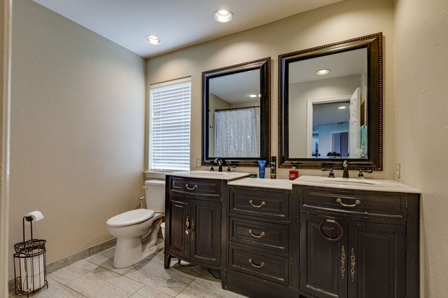 Shared Bathroom with double vanity and marble finish floors | Image 29