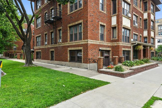 Beautiful brick building with historic architectural accents, landscaped entry, and tree-lined sidewalk. | Image 30