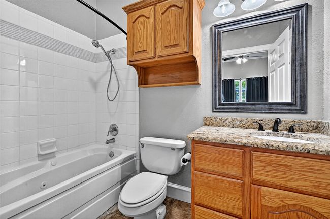 Bathroom with vanity, washtub / shower combination, toilet, baseboards, and a ceiling fan | Image 30